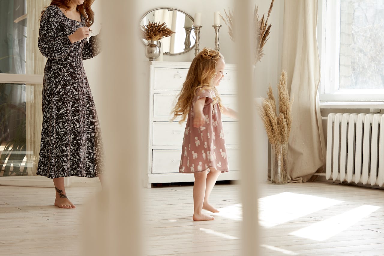 mother and daughter at home next to a panel heater
